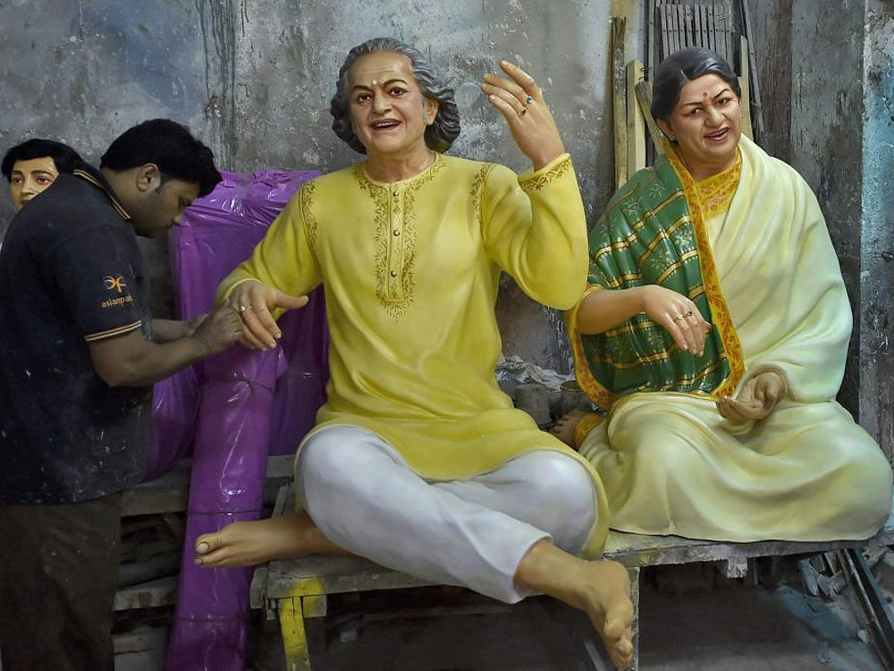  An artisan giving final touches on a fibreglass statue of sitar exponent Ravi Shankar and legendary singh Lata Mangeshkar at Kumartuli in Kolkata on Monday. The statues of great Indian personalities will be sent to Delhi for the forthcoming Republi...