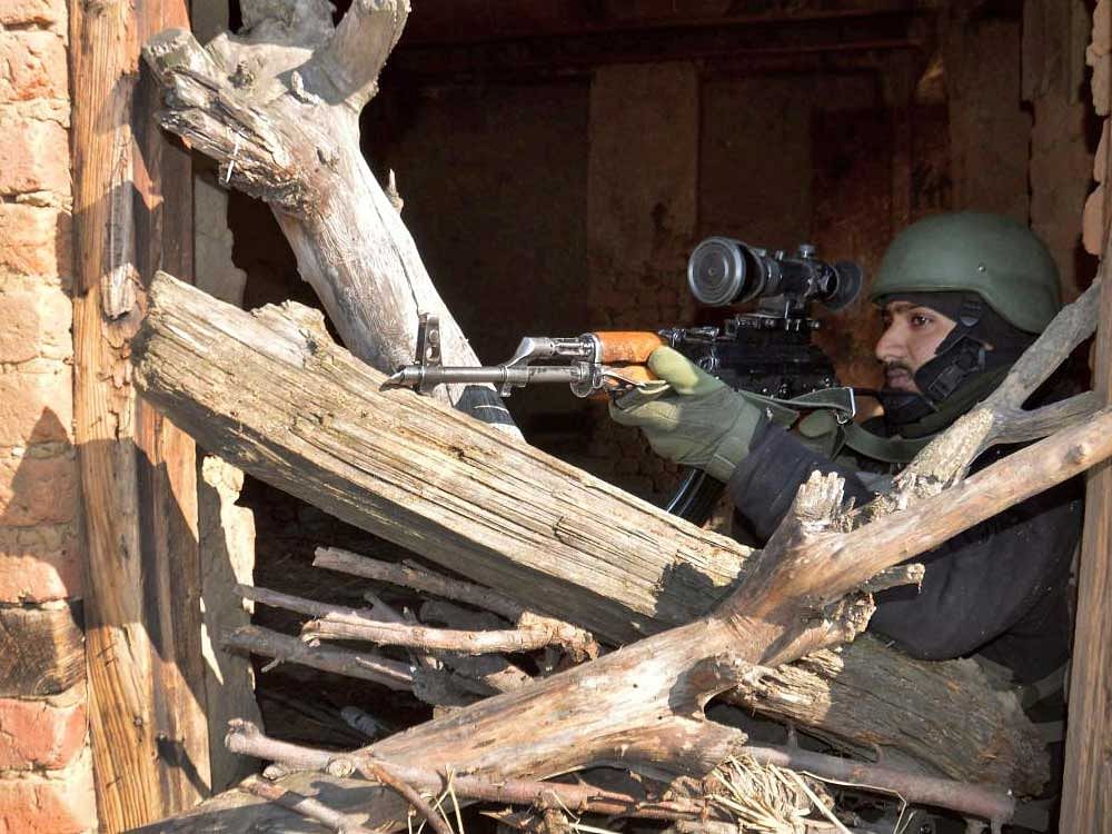 An Army soldier takes position during a gun battle in which two militants were killed, at Kokarnag in Anantnag district of South Kashmir on Tuesday. A civilian was also killed during clashes which erupted at Khudwani area soon after the killing of a ...