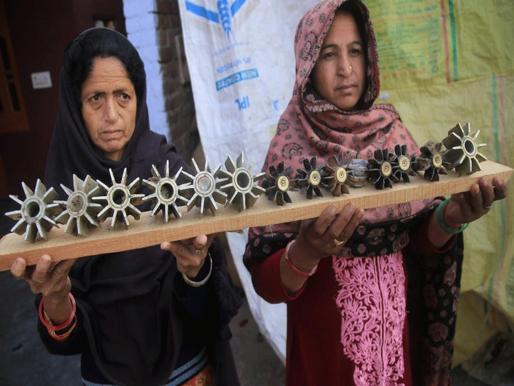 Women show mortar shells at Suchetgarh after shelling from the Pakistani side of the border, in R S Pura Sector, about 25 km from Jammu on Sunday. PTI Photo