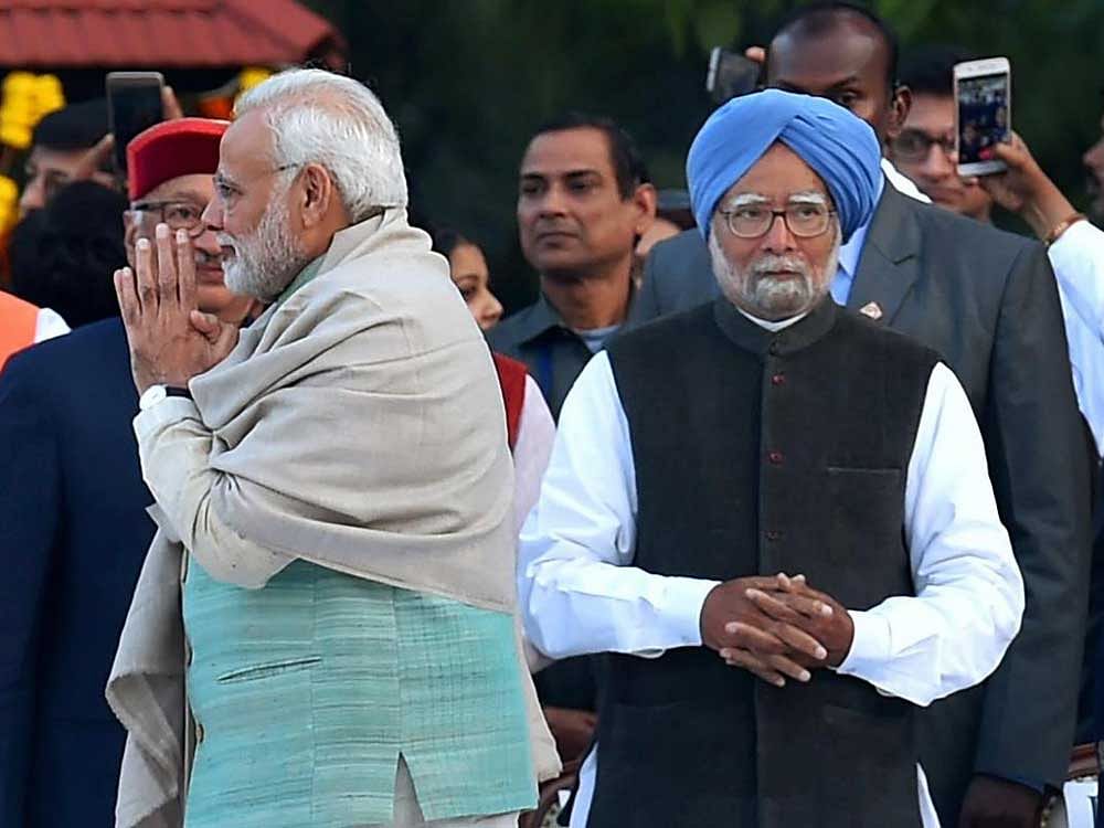  Prime Minister Narendra Modi pays tribute at Mahatma Gandhi's memorial on his 70th death anniversary at Gandhi Smriti in New Delhi on Tuesday. Former prime minister Manmohan Singh is also seen. PTI Photo