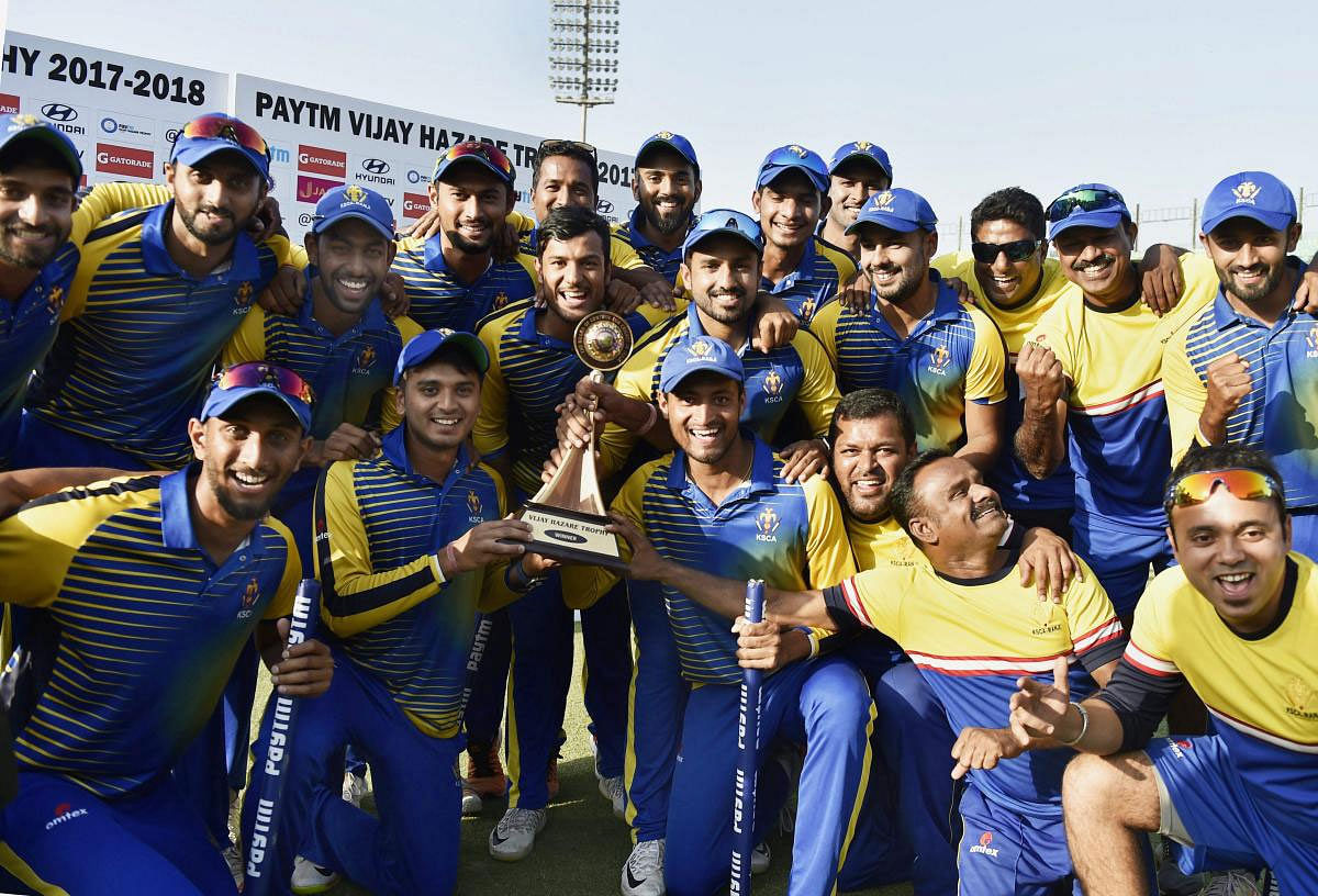 Karnataka players pose with trophy after winning Vijay Hazare trophy finals against Saurashtra at Feroz Shah Kotla stadium in New Delhi on Tuesday. PTI Photo