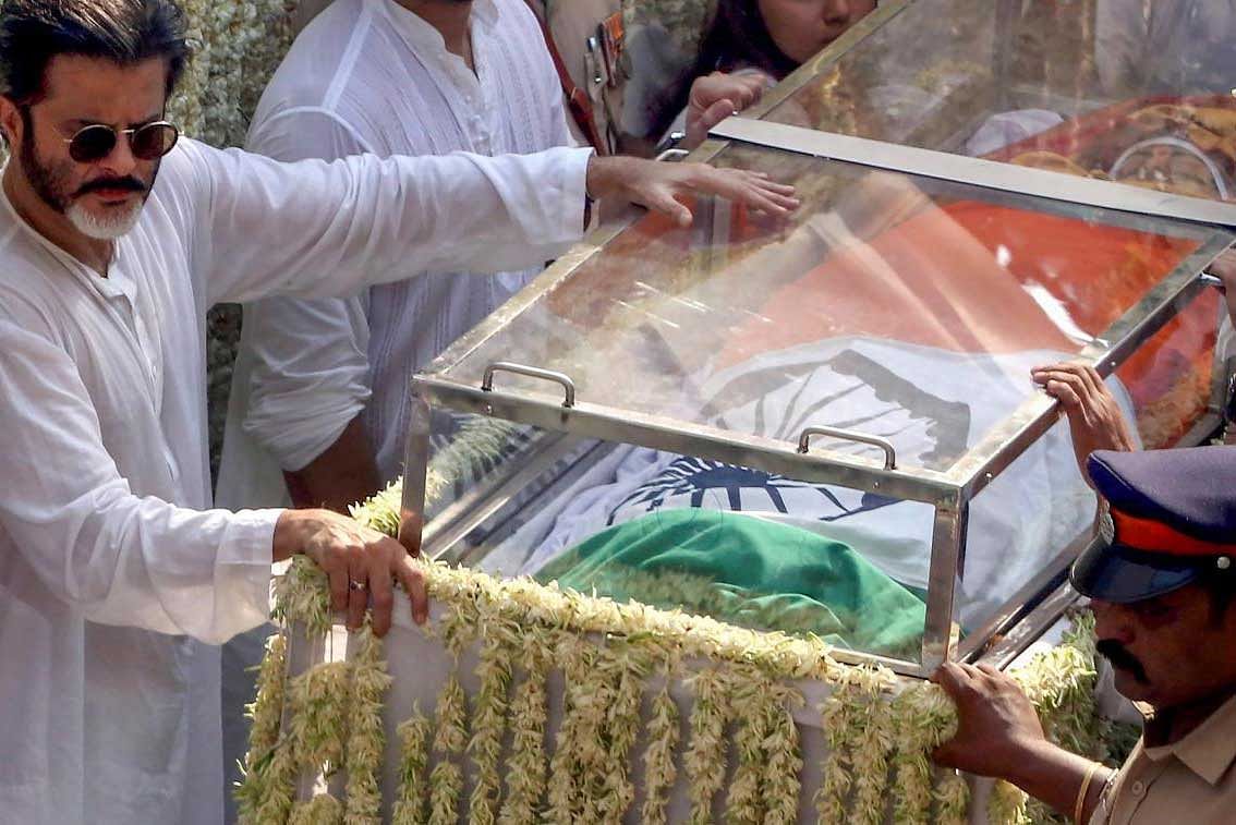 Bollywood actor Anil Kapoor near actress Sridevi's mortal remains, wrapped in the national flag and placed in a glass casket, during her funeral procession in Mumbai on Wednesday. PTI Photo