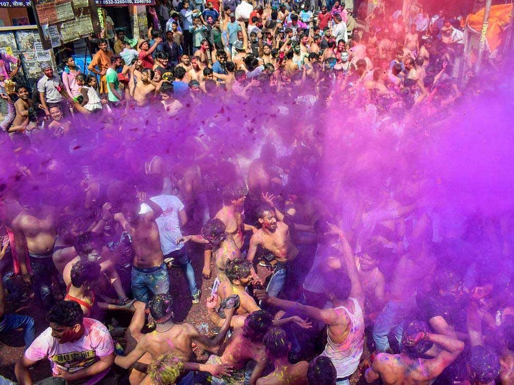 Revelers smear colour in the air as they joyfully dance during the 'Holi' festival celebration, in Allahabad on Friday.