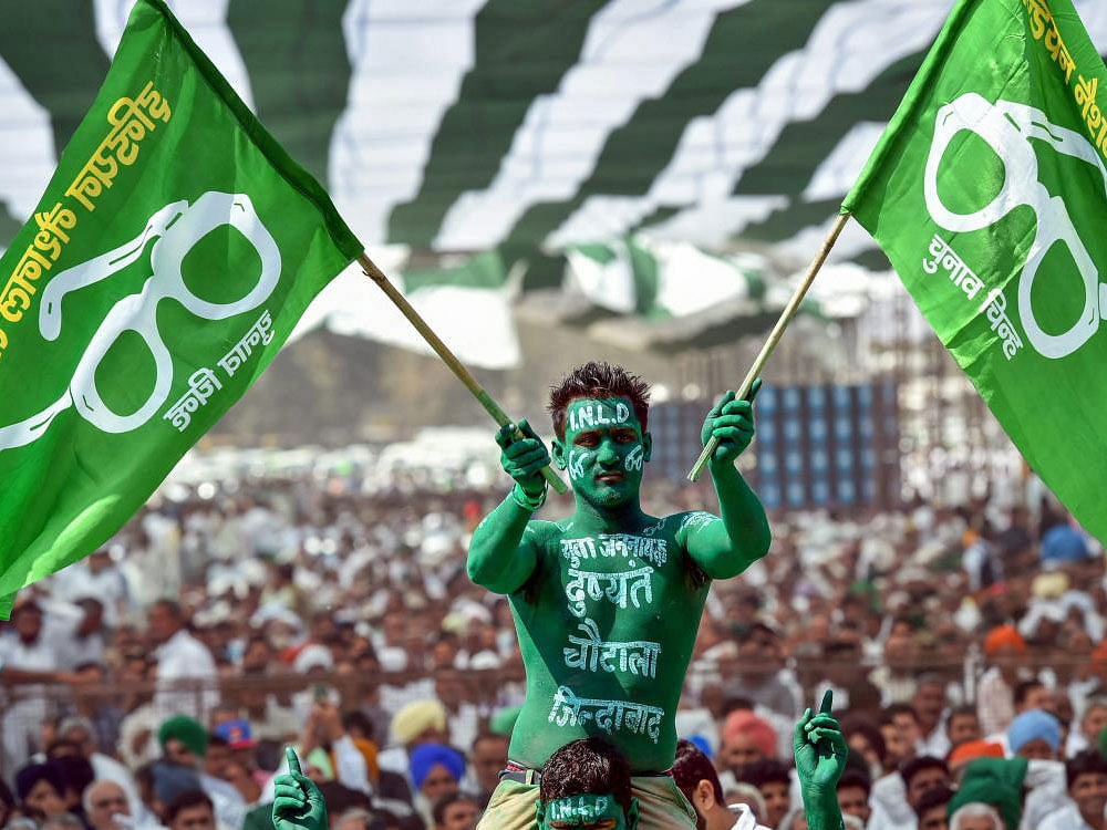 An Indian National Lok Dal (INLD) supporter waves party flags during farmers' rally at Ramlila ground in New Delhi on Wednesday.