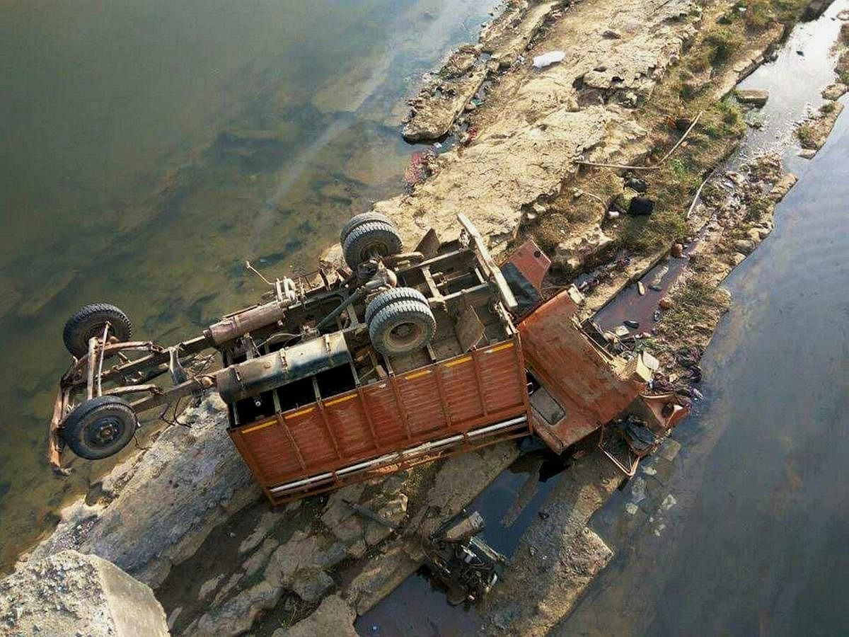 The mangled remains of a mini-truck carrying a marriage party which fell from a bridge is seen lying into the dry Son riverbed near Amelia village in Sidhi District of Madhya Pradesh on Wednesday. At least 22 people were killed and many others suffered serious injuries in the accident. PTI