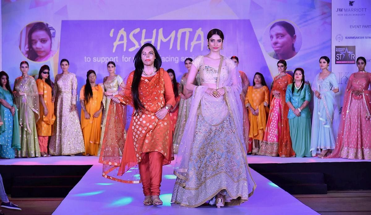  An acid victim walks the ramp with a model during a fashion show held in solidarity with women facing social atrocities, New Delhi on Thursday. PTI Photo