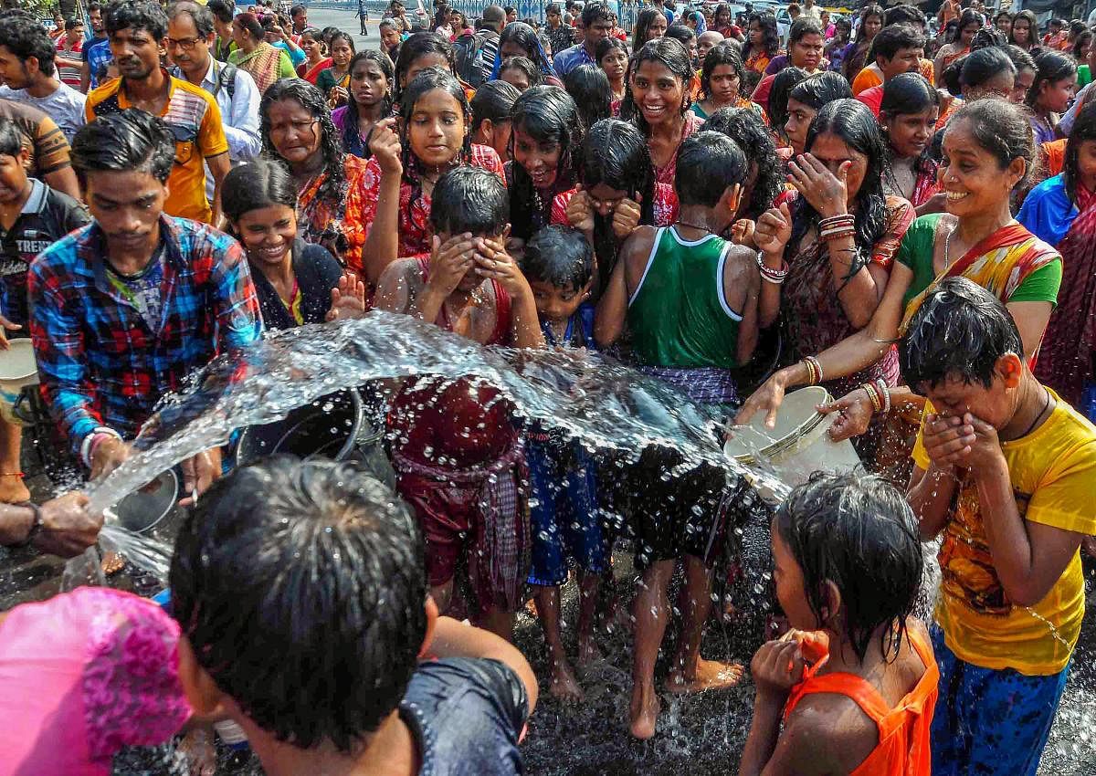 A man shower water on the devotees to cool them during 'Dandi' rituals as part of 'Goddess Shitala Puja' in Kolkata on Saturday. PTI Photo 