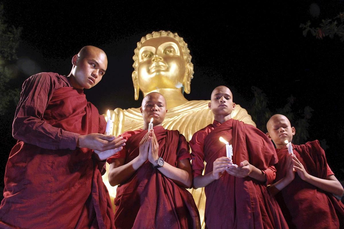 Buddhist monks offering prayers at the statue of Lord Buddha on the eve of Buddha Purnima in Bhopal. PTI Photo