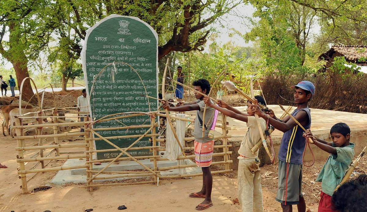 Tribals hold bows and arrows near a Patthalgarhi spot at Maoist-affected village Siladon under Khunti district of Jharkhand on Tuesday. The Patthalgarhi movement says that the “gram sabha” has more weight than either the Lok Sabha or the Vidhan Sabha in scheduled areas. PTI Photo