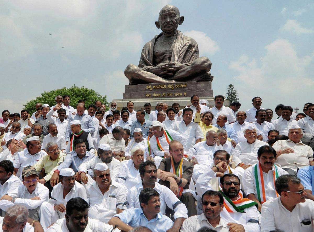 JD(S) Supremo H D Deve Gowda, Congress leader Gulam Nabi Azad, former CM Siddaramaiah, JD(S) leader H. D. Kumaraswamy with JD(S) and Congress party supporters and MLAs stage dharna in front of Gandhi Statue near Vidhan Soudha to protest against Karnataka Governor Vajubhai Vala's invitation to BJP to form the government, in Bengaluru on Thursday. PTI Photo