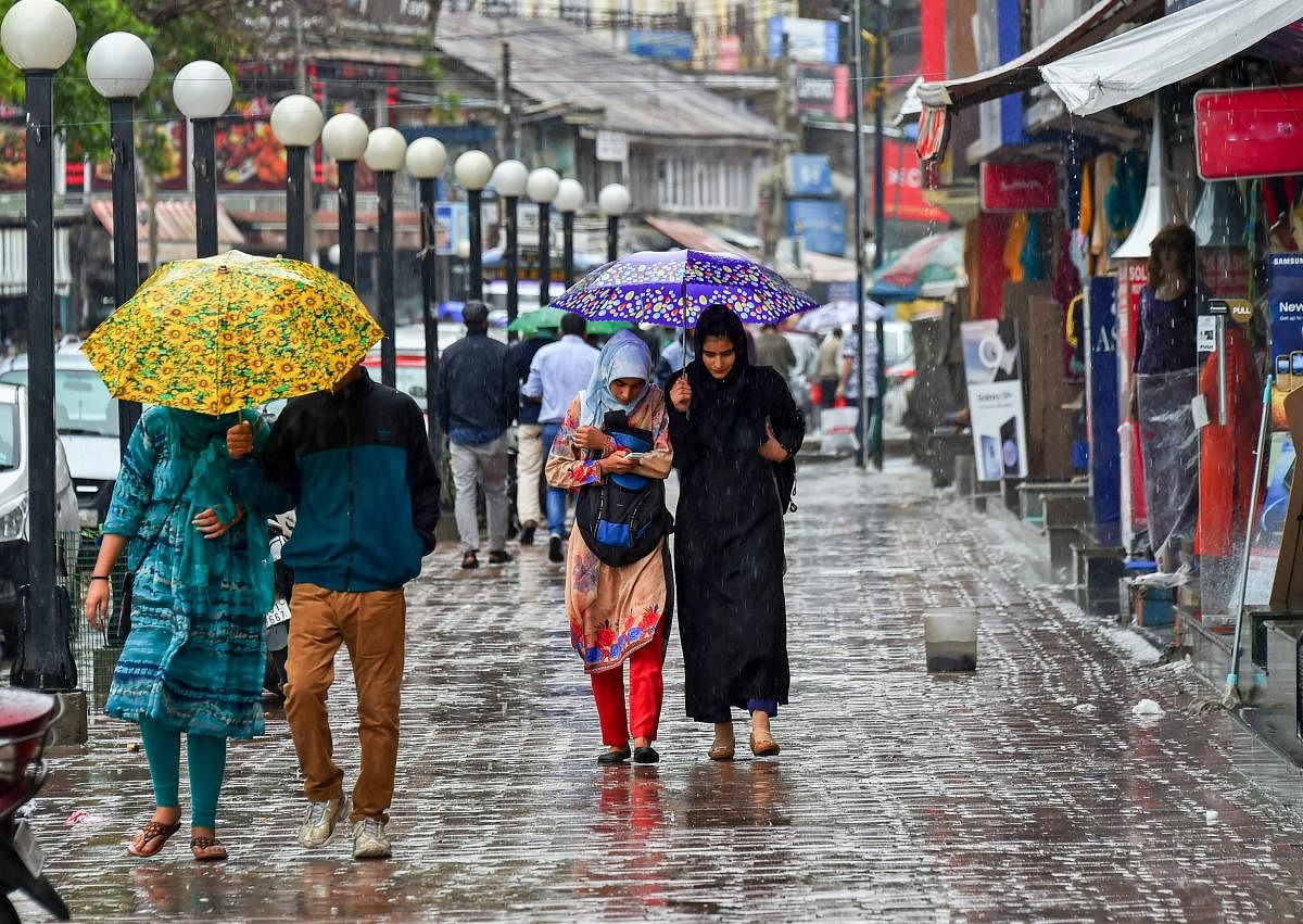 Pedestrians walk with umbrellas during heavy rains in Srinagar on Friday, June 29, 2018. Heavy rains lashed several parts of the Valley, including the state's summer capital today, even as the authorities advised people residing near streams in south Kashmir to remain vigilant. (PTI Photo)