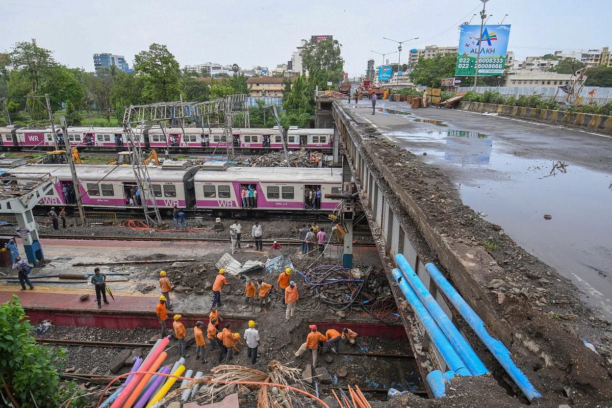 Workers carry out repair work of Gokhale road overbridge (ROB) that collapsed on the Western Railway tracks on June 03, 2018, at Andheri station following heavy rains, in Mumbai on Wednesday, July 04, 2018. (PTI Photo)
