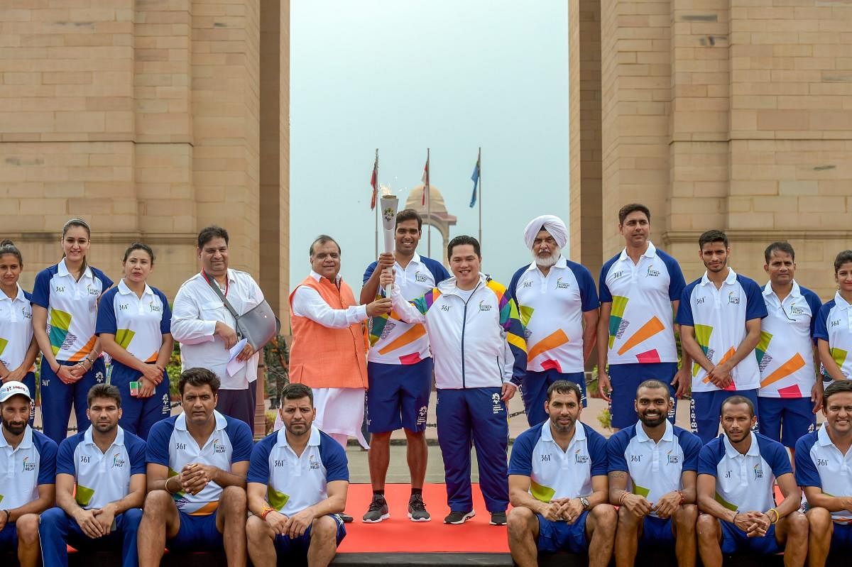 Offcials and athletes pose for a group photo in front of the India Gate during the 'Torch Relay' for the 18th Asian Games Jakarta Palembang 2018, after the flame - lighting ceremony, at India Gate in New Delhi on Sunday, July 15, 2018. (PTI Photo/Vijay Verma)