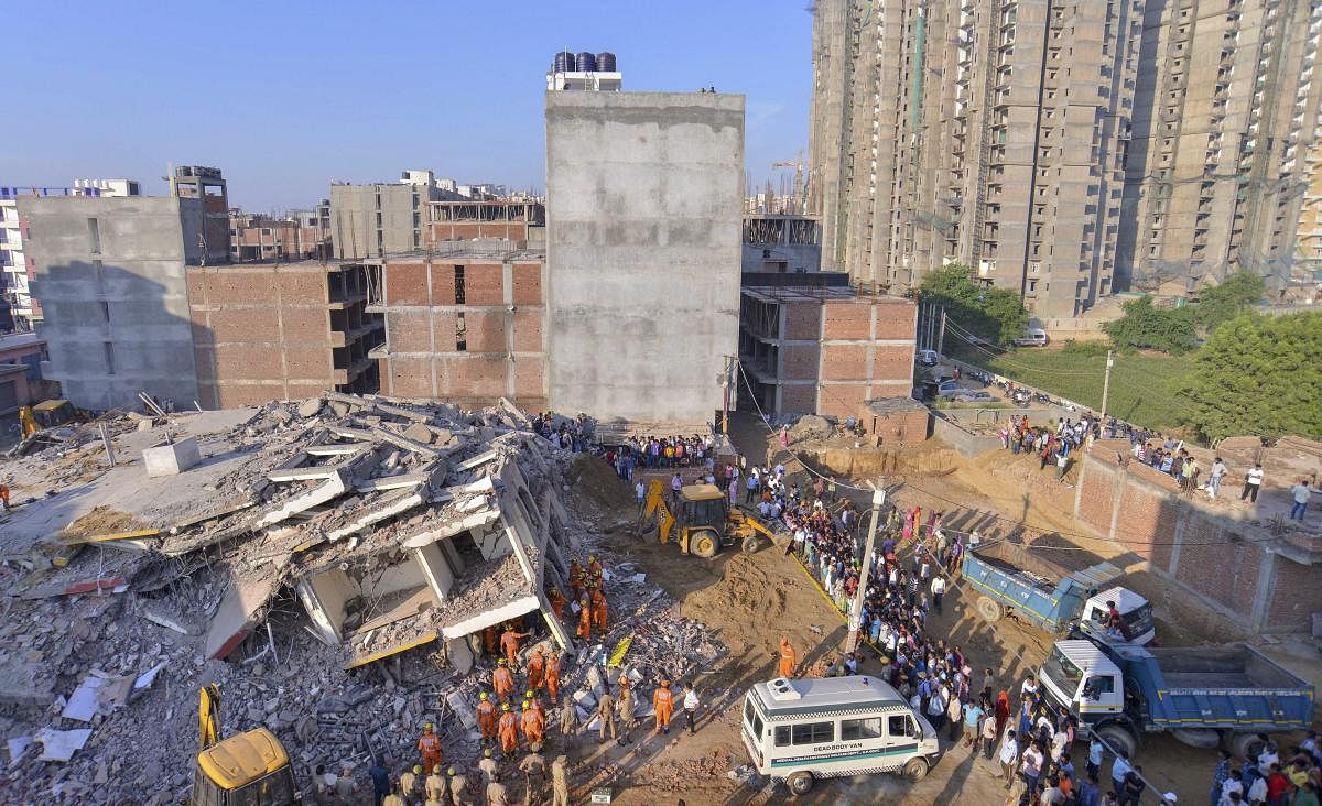 NDRF and local authorities carry out rescue work at the site of a collapsed building at Shahberi village, in Greater Noida West on Wednesday, July 18, 2018. A six-storey under-construction building collapsed in Greater Noida, killing at least two persons and trapping several others under the debris. (PTI Photo)