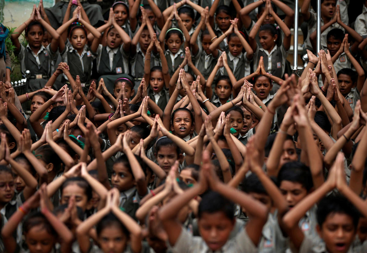 School students pray for rain at a temple in Ahmedabad, India, July 19, 2018. (REUTERS/Amit Dave)