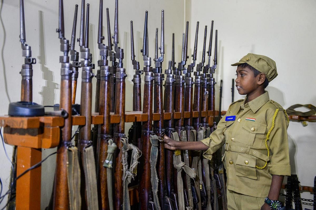 Shashank, a 12-year-old Thalassemia patient who aspired to become a police inspector, inspects arms as he takes charge of the Chamarajpet police station for a day, in Bengaluru. (PTI Photo)