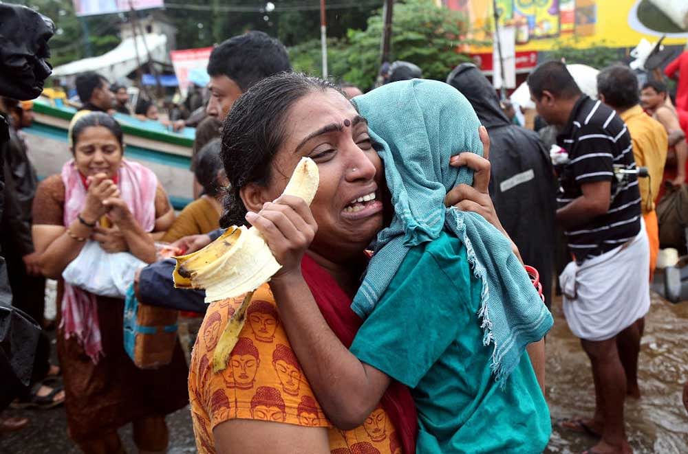 A woman cries as she holds her son after they were evacuated from a flooded area in Aluva in the southern state of Kerala. Reuters Photo
