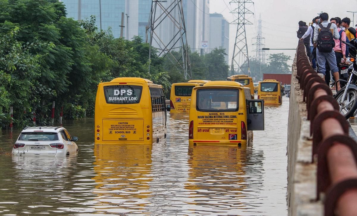 School buses moves slowly at a waterlogged road after heavy rains in Gurugram on Tuesday, Aug 28, 2018.