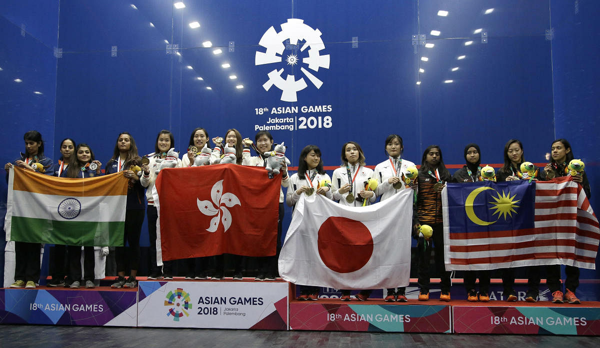 From left to right, team combined India, team Hong Kong, team Japan and team Malaysia stand on the podium during the victory ceremony for women's squash competition at the 18th Asian Games in Jakarta, Indonesia, Saturday, Sept. 1, 2018. AP/PTI