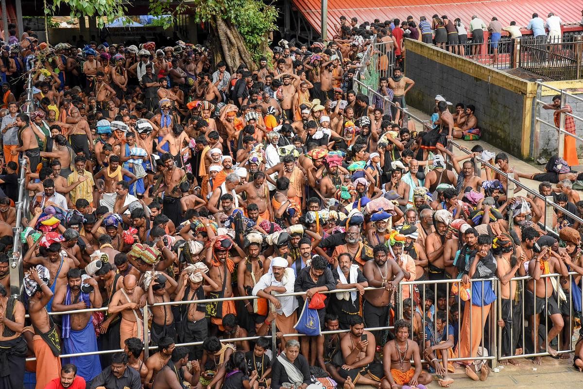 Devotees wait for opening of the Lord Ayyappa Temple in Sabarimala, Kerala. Tension was witnessed outside the temple that was opened for the first time for women of all ages on Wednesday, following a 28 September Supreme Court verdict that turned over the age-old custom of not admitting women between the age group of 10-50 years of age. PTI