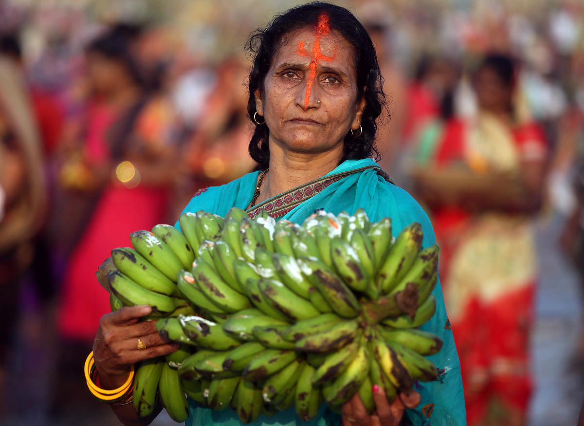 A Hindu woman holds bananas as she worships the Sun god in the waters of the Arabian Sea during the religious festival of Chhath Puja in Mumbai, India, November 13, 2018. REUTERS