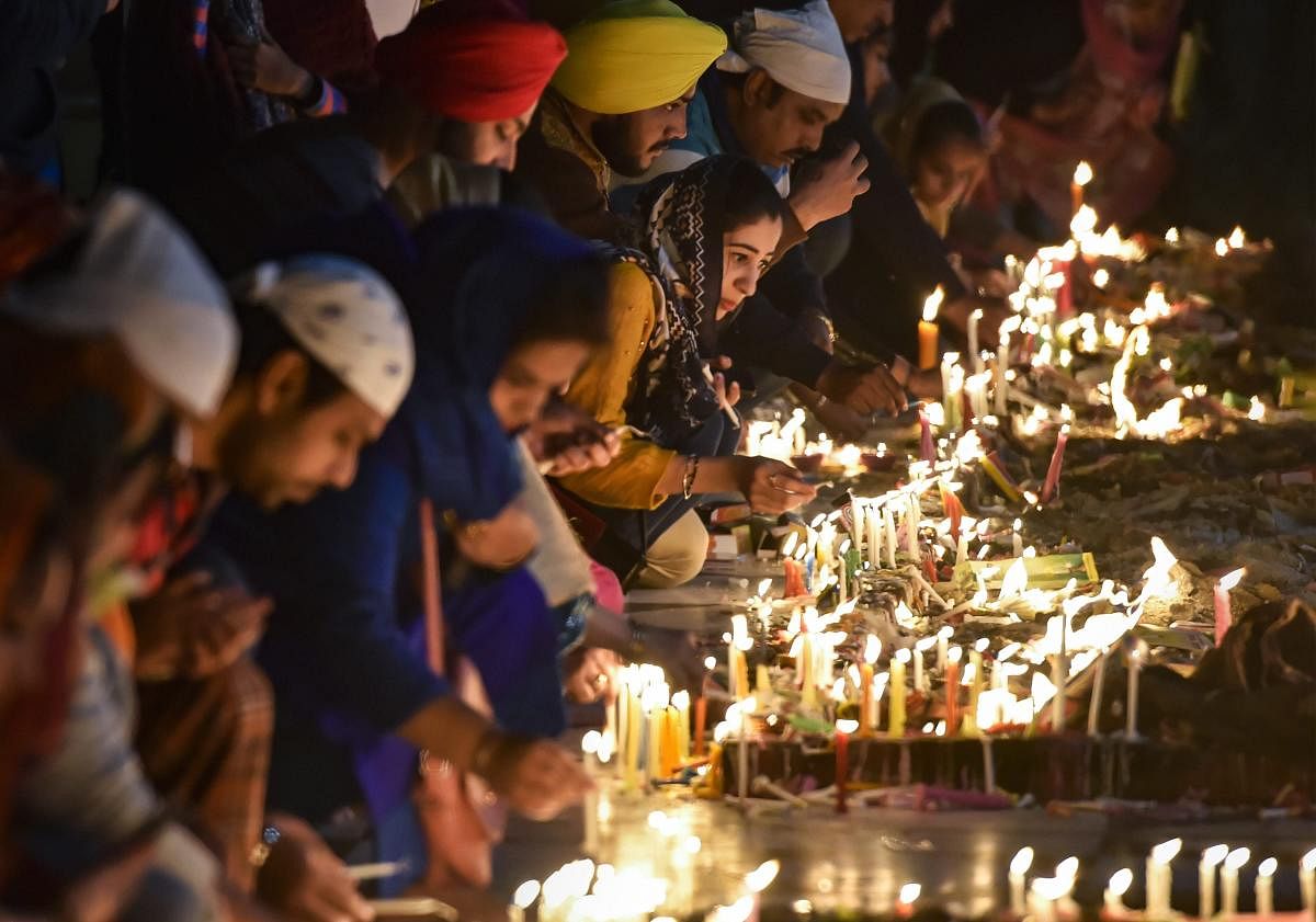 New Delhi: Devotees light candles at Bangla Sahib Gurudwara on the occasion of 550th birth anniversary of Guru Nanak Dev ji, in New Delhi, Friday, Nov. 23, 2018. (PTI Photo/Ravi Choudhary) 