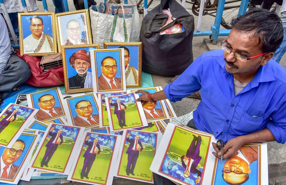 A man sells photos of Dr Bhimrao Ramji Ambedkar at a rally organised on the occasion of his death anniversary, in Kolkata. (PTI Photo)