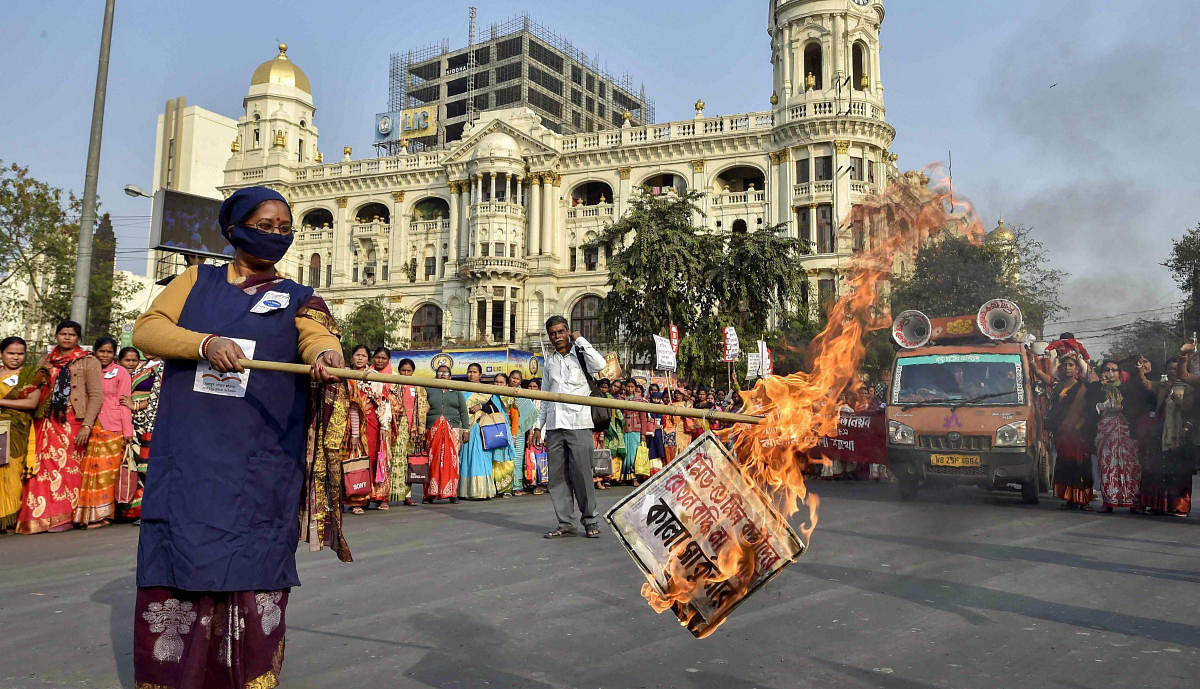 Mid-day meal workers burns a copy of the circular during a protest rally dmanding 'equal pay for equal work', in Kolkata. PTI