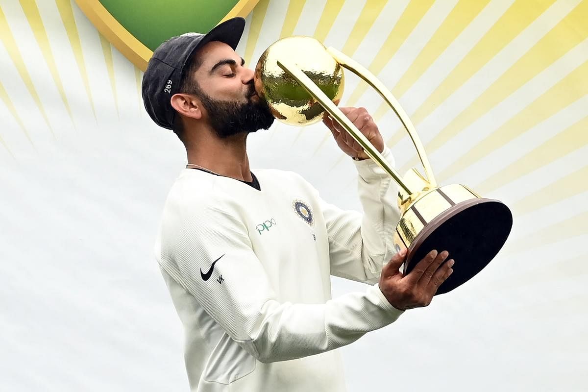 Virat Kohli kisses the Border-Gavaskar trophy as the Indian team celebrates their series win on the fifth day of the fourth and final cricket Test against Australia at the Sydney Cricket Ground in Sydney on January 7, 2019. (AFP)