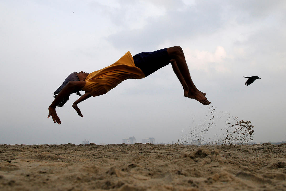 A boy practices somersaulting as he exercises at a beach in Kochi, India, March 11, 2019. REUTERS/Sivaram V