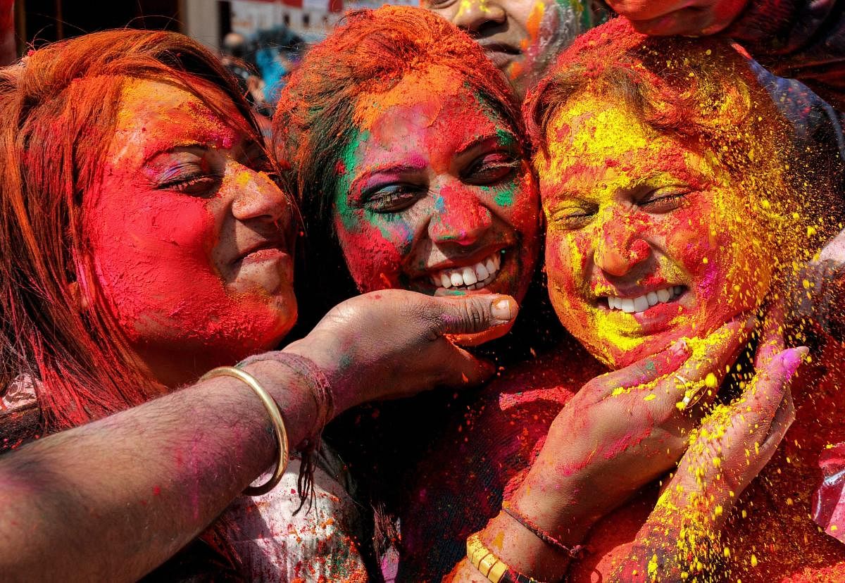 People smear colours at each other during Holi celebrations at Durgiana Temple in Amritsar. (PTI Photo)