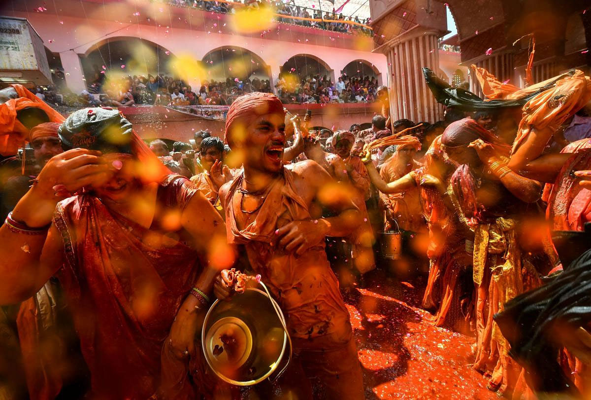 Revellers participate in Huranga, celebrated one day after the Holi festival, at Dauji Temple in Mathura, Friday, March 22, 2019. Villagers gather in the courtyard of the temple, where men pour buckets of saffron-tinged water on women, who retaliate by tearing the?ir? shirts off and ?thrashing them with it. (PTI Photo)