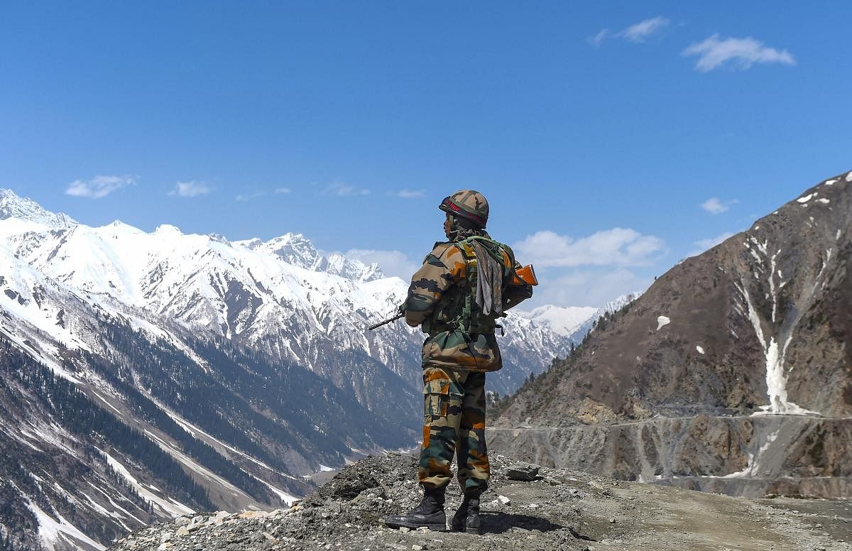 An army soldier stands guard at Zojila Pass, situated at a height of 11,516 feet, on its way to frontier region of Ladakh. (PTI Photo)