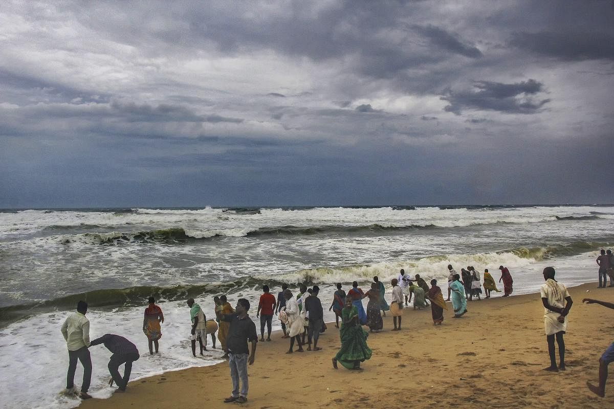 Villagers at the beach as dark clouds hover above the sea ahead of cyclone 'Fani', in Puri. (PTI Photo)