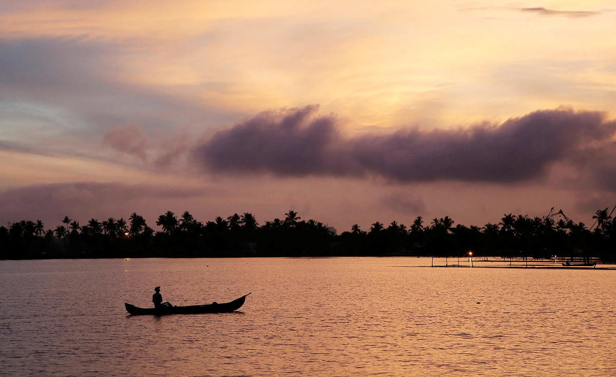 A man rows his boat in the tributary waters of Vembanad Lake against the backdrop of pre-monsoon clouds on the outskirts of Kochi, India, June 7, 2019. REUTERS/Sivaram 