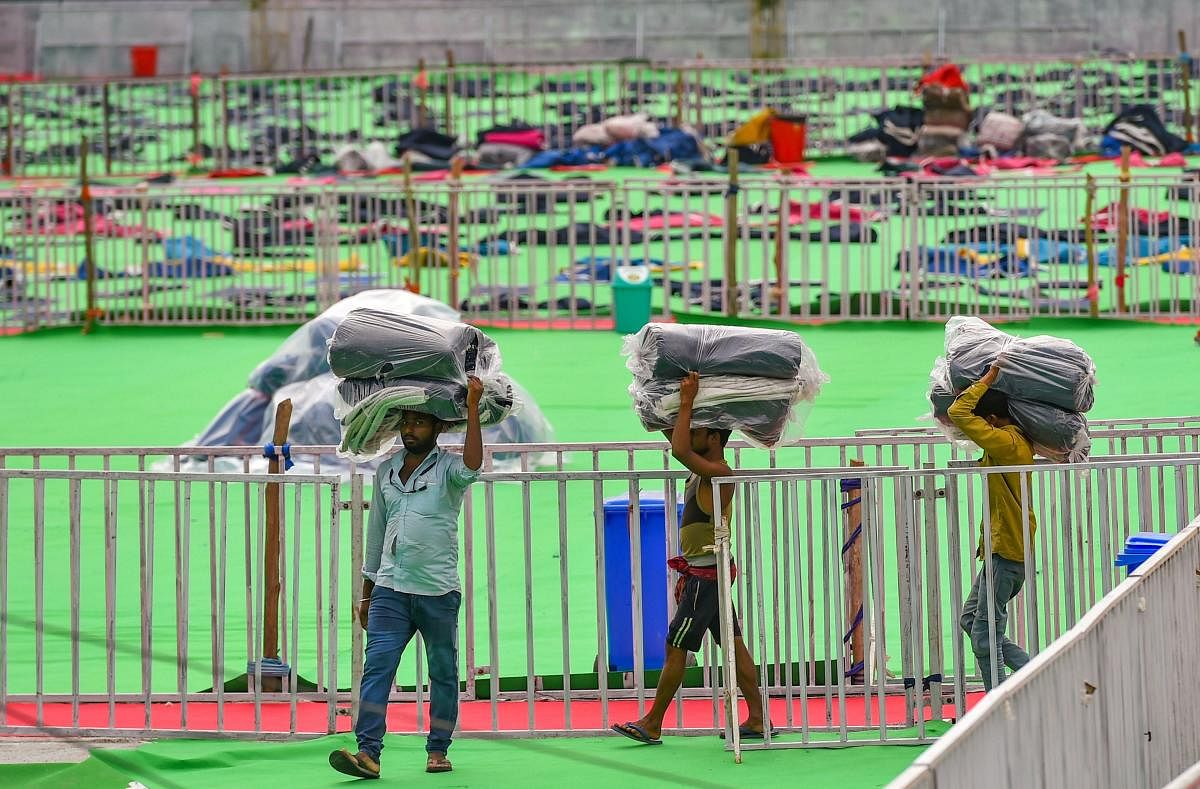 Workers carry yoga mats in preparation at the venue of 5th International Yoga Day, in Ranchi, Thursday, June 20, 2019. Prime Minister Narendra Modi will be joining the programme in the city on Friday. PTI
