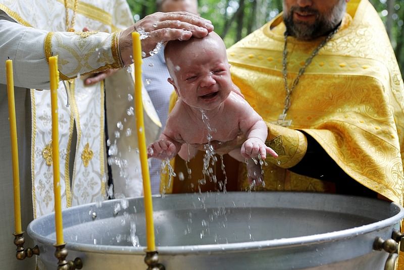 Orthodox priests baptize a child during a mass baptism ceremony marking the anniversary of the Christianisation of the country, which was then known as Kievan Rus’, in Stavropol, Russia. (Reuters)