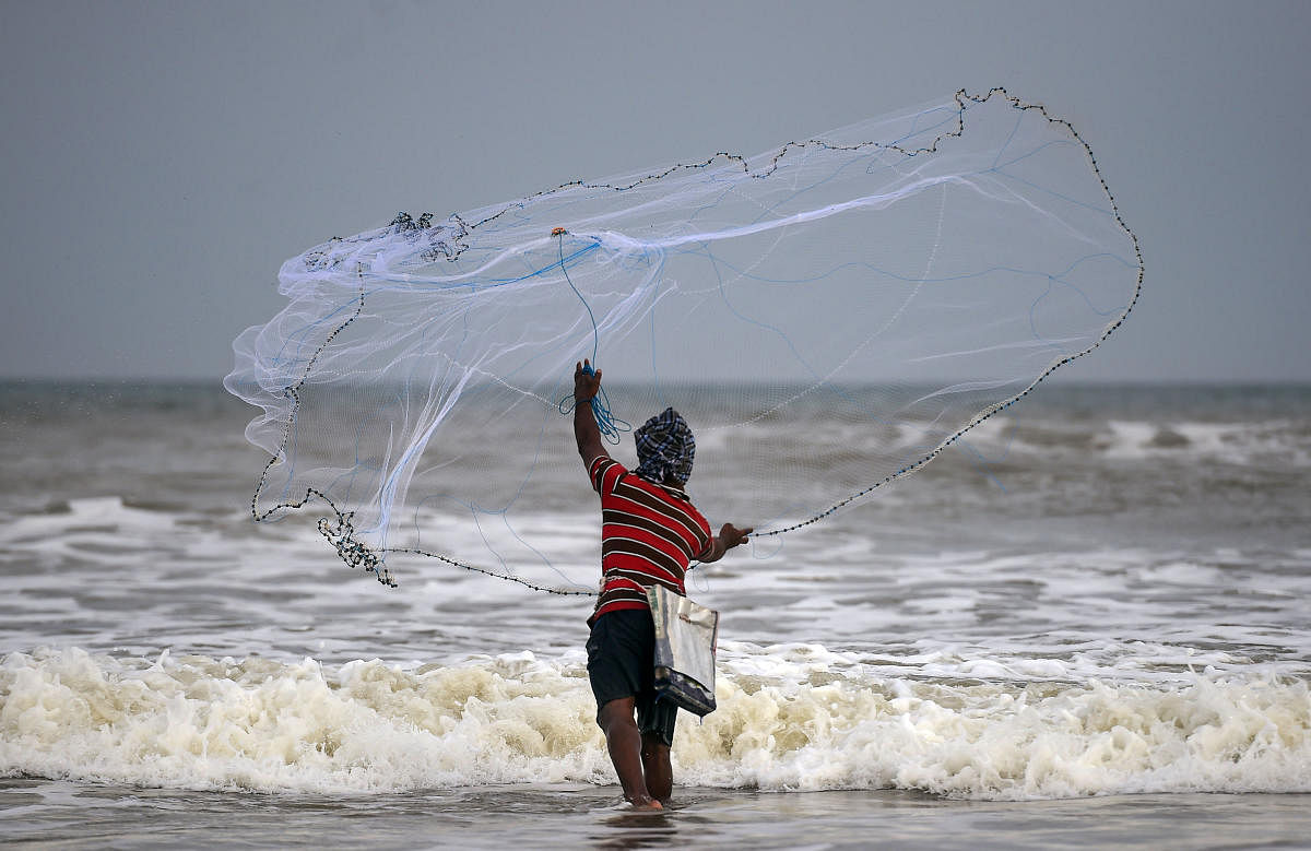 A fisherman casts his net at Marina Becah, in Chennai. PTI
