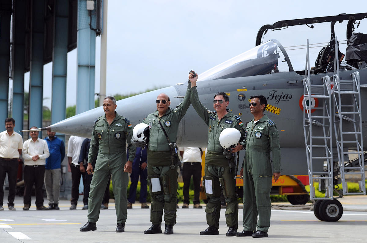 Defence Minister Rajnath Singh and Air Vice Marshal N Tiwari, Project Director, National Flight Test Centre, ADA Bangalore along with staff pose after flying the Tejas fighter aircraft from the HAL airport in Bengaluru on Thursday. (DH Photo/Pushkar V)