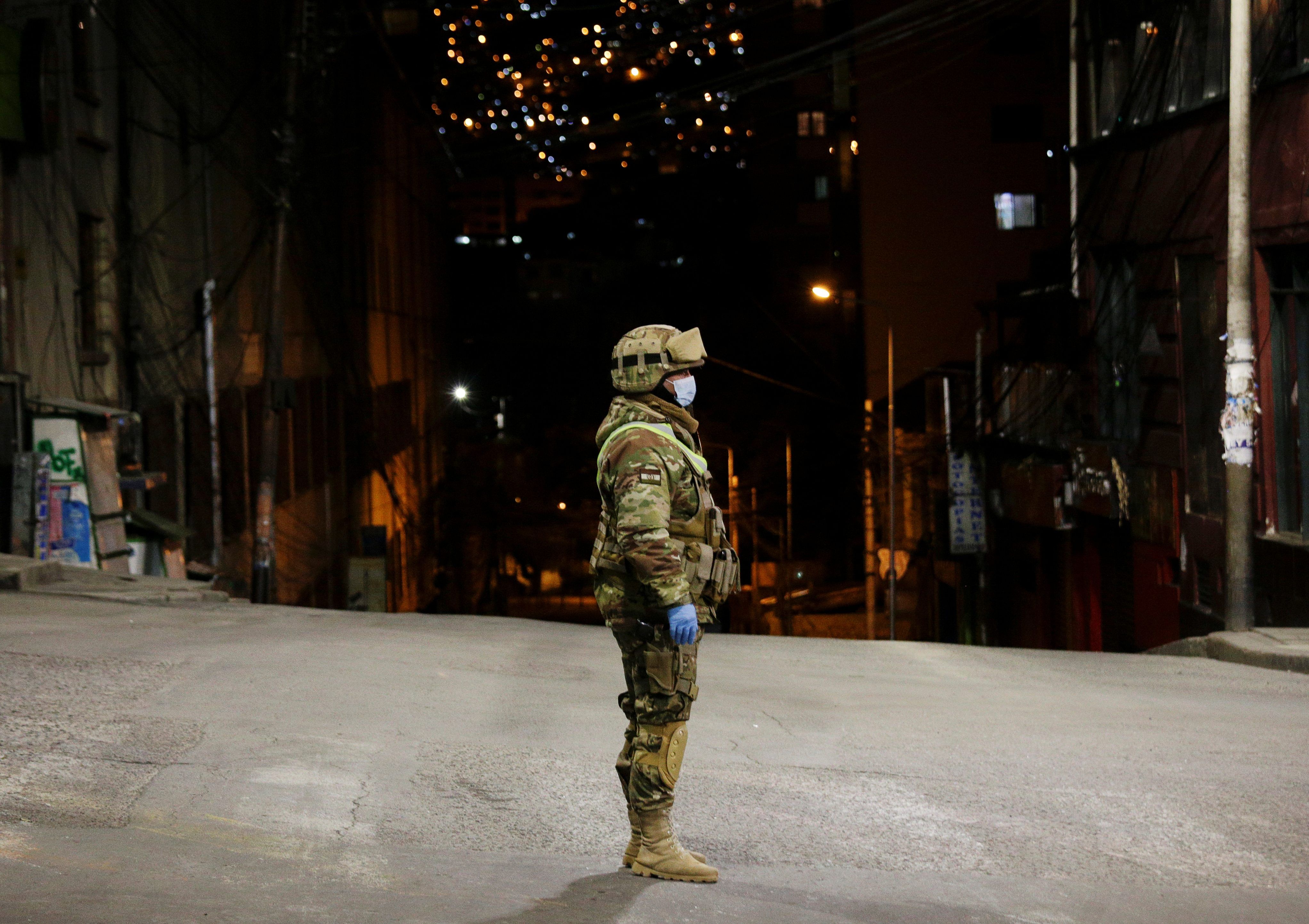 A Bolivian military officer stands on a street in the empty city centre of La Paz, after the government asked residents to stay indoors to prevent the spread of the coronavirus disease. (Credit: Reuters)