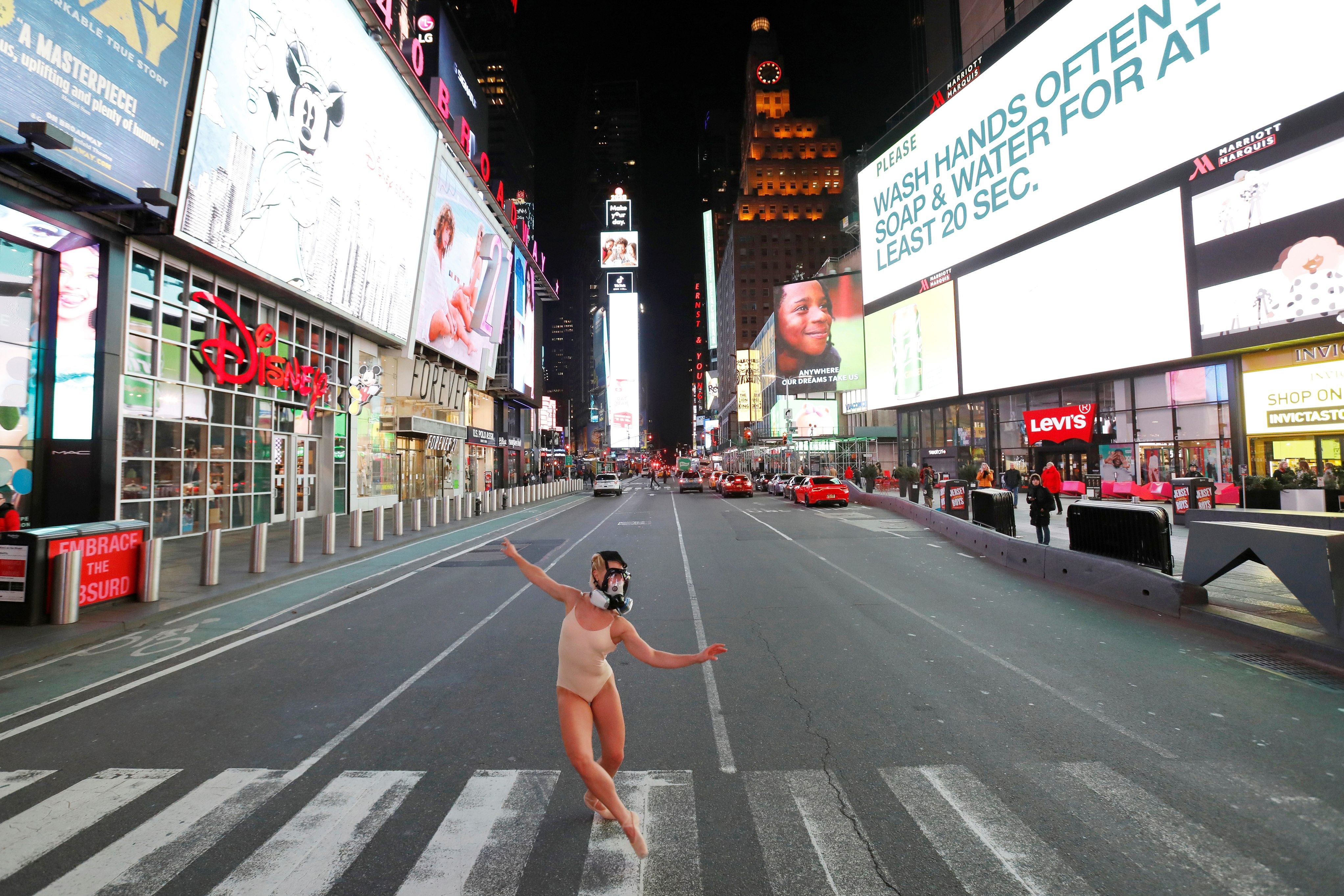 Ballet dancer and performer Ashlee Montague of New York wears a gas mask while she dances in Times Square. (Credit: Reuters)
