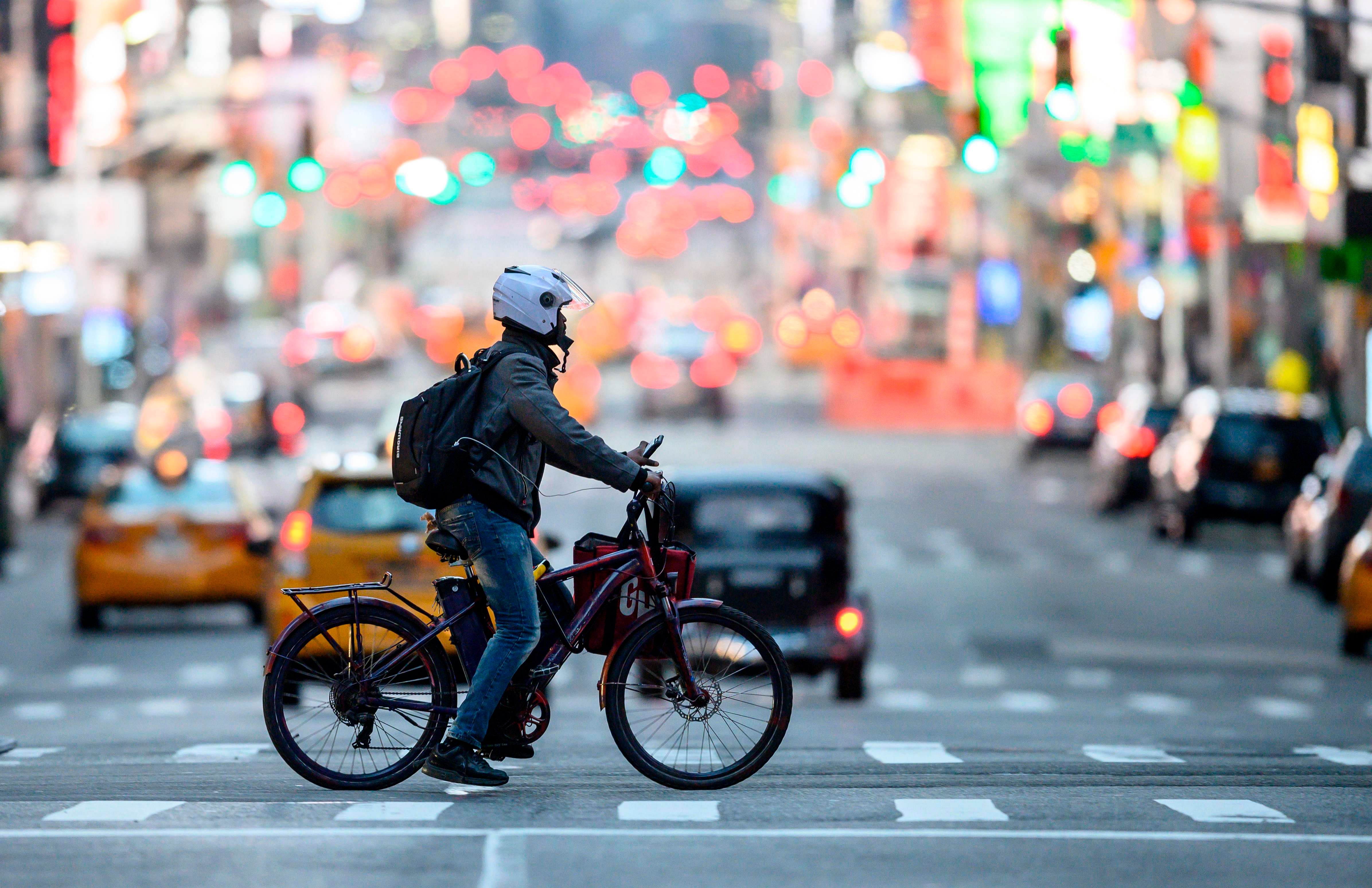 A food delivery man crosses the street in Times Square in Manhattan. (Credit: AFP)