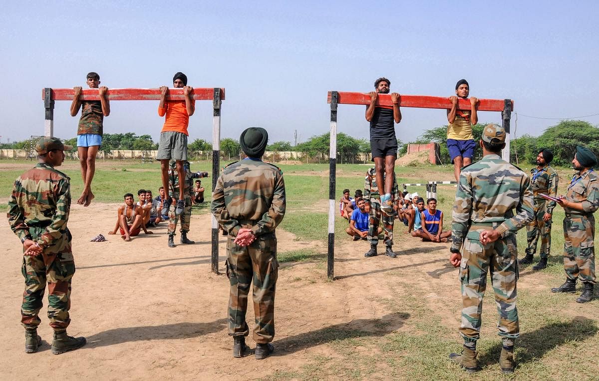 Army officer watch candidates perform pull-ups during an army recruitment rally at Khasa, approximately 15 Kms from Amritsar on Saturday. (AP/PTI Photo)