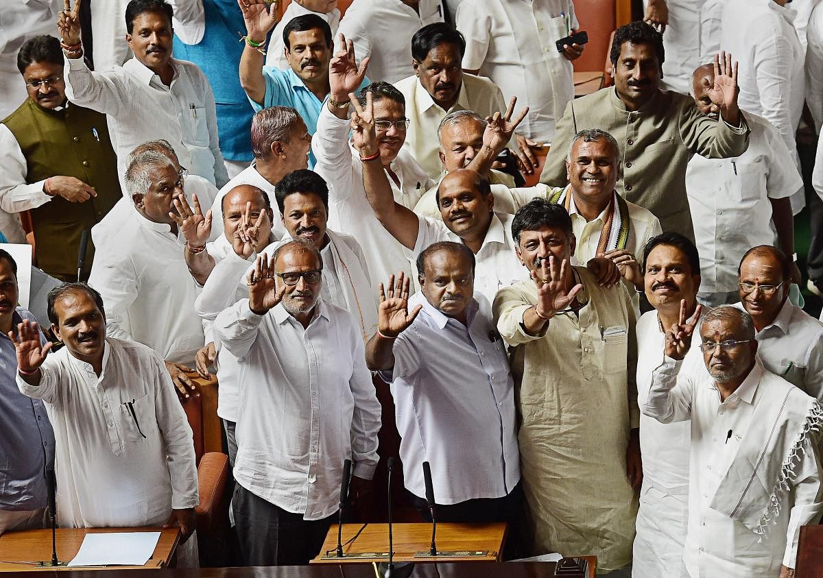   Karnataka Chief Minister H D Kumaraswamy, with other JD(S) and Congress leaders, waves to the media after his coalition government won the trust vote by voice vote, at Vidhana Soudha in Bengaluru, on Friday.  PTI Photo