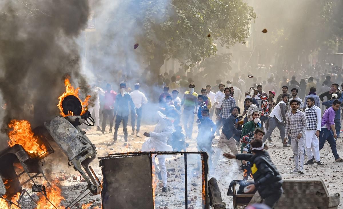 Vehicles set ablaze as protestors throw brick-bats during clashes between a group of anti-CAA protestors and supporters of the new citizenship act, at Jafrabad in North East Delhi. (PTI Photo)