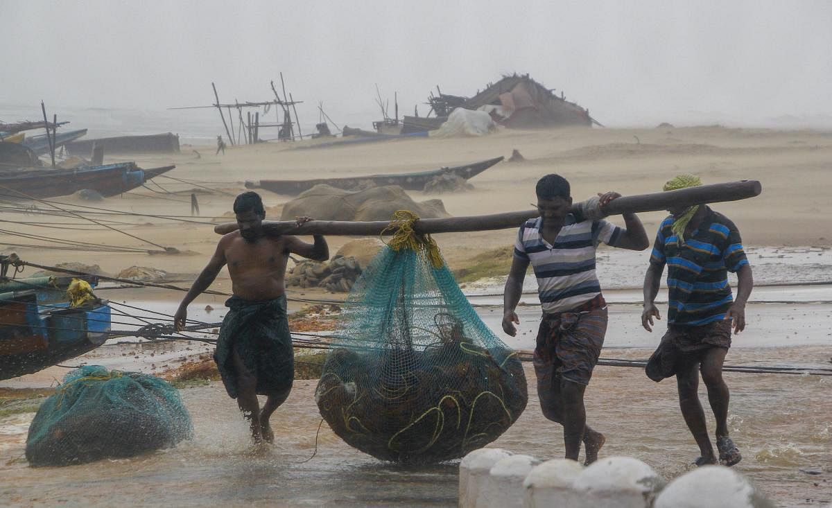  Fishermen engaged in their work as Cyclone Titli hits the coast starting with surface wind effect reaching speeds of 126 kmph at Gopalpur, in Ganjam. (PTI photo)
