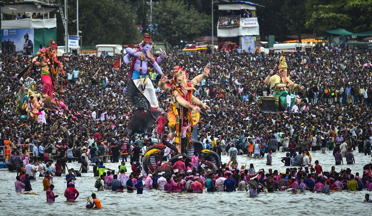 Devotees carry Ganesha idols for immersion to mark the end of Ganesh Utsav celebrations, at Girgaum Chowpatty in Mumbai. PTI