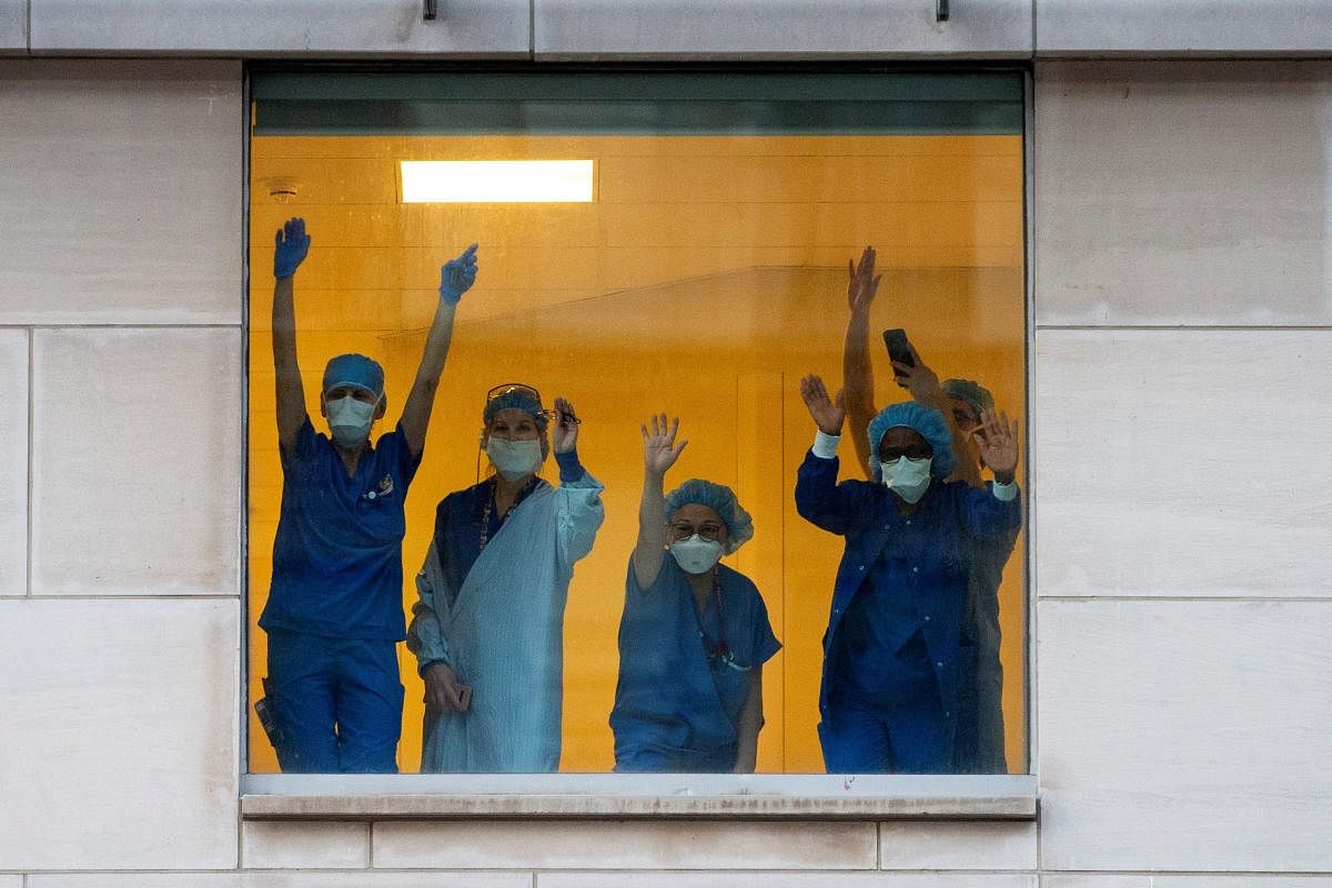 Healthcare workers clap and wave as Toronto Police and the city's front-line responders pay tribute to healthcare workers along University Avenue as the number of coronavirus disease (COVID-19) cases continue to grow in Toronto, Ontario, Canada April 19, 2020. Credit: Reuters Photo 