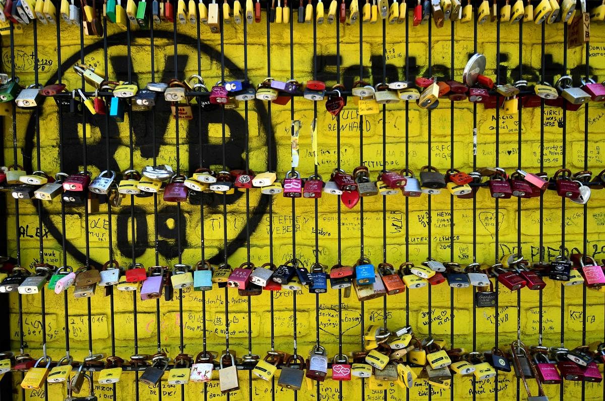 A picture taken on May 14, 2020 shows love locks on a fence in front of the Signal Iduna Park stadium of Bundesliga football club Borussia Dortmund in Dortmund, western Germany. (Photo by AFP)