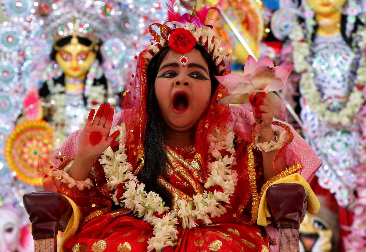 Nidhi Bhattacharjee, 5, dressed as a Kumari, yawns as she is worshipped by Hindu priests (unseen) as part of a ritual during the Durga Puja festival celebrations in Agartala, India, October 6, 2019. (Photo by Reuters)